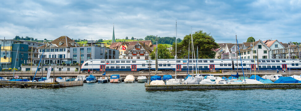 Wadenschwil, Switzerland - July 1, 2024: A Swiss Railways train of SBB passes the marina in Wadenswil on Lake Zurich