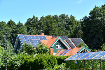 Obraz premium Solar Panel station on village House Roof. Solar panels on tiled roof