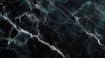 A close-up of black marble, showcasing its smooth surface and the striking contrast of white veins running through it.
