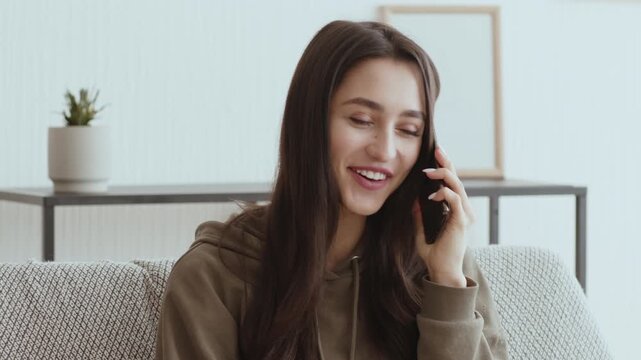 Quarantine communication. Positive millennial girl talking on cellphone at home