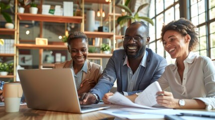 Three people are sitting around a table with a laptop open in front of them