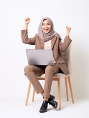 Happy young Malaysian woman celebrating success online