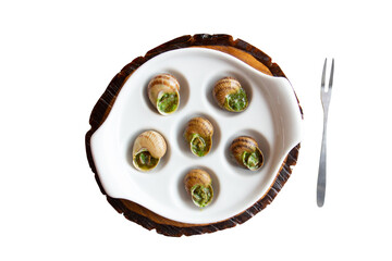 Snails stuffed in Burgundy on the ceramic dish with six holes and handles, snail fork on the table. Close-up top view, isolated on a white background