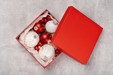Red and white Christmas baubles in a box flat lay. Merry Christmas and Happy New Year seasons greetings card. Copy space. Festive border