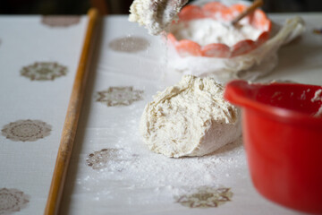 pouring flour on a raw dough 