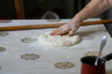 Old woman hand kneading dough
