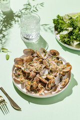 Vongole with basil and onion on a white plate
