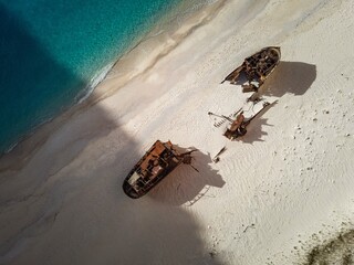 Aerial view of shipwrecks on a sandy beach.