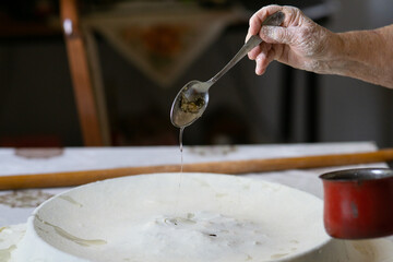 Rolled out dough and rolling pin on a table. Pouring flour on the dough