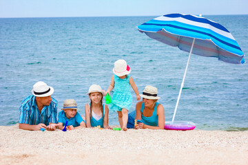 A Happy family playing by the sea shore on the sand background