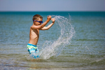 A Happy child playing in the sea swim in nature