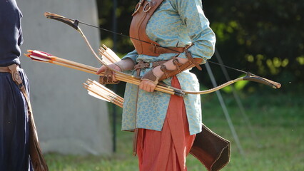 Medieval female archer with bow and arrow in hand. Women's fashion of the Middle Ages. Leather...