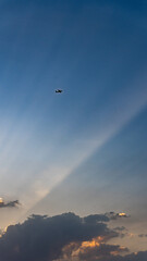 An airplane in the sky and a ray of sunshine