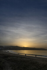 Obraz premium Sunset over the horizon with calm beach