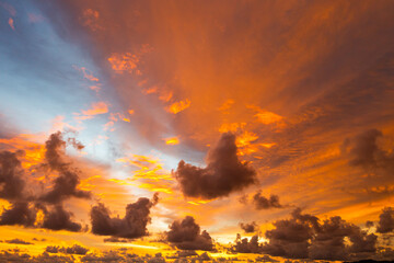 Fototapeta premium A breathtaking aerial view capturing a vibrant sunset over the Phuket countryside. The sky is ablaze with rich hues of yellow, orange, pink, and purple, while dramatic clouds float above the city