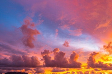 Fototapeta premium .The sky is painted with hues of deep orange, red, and pink, gradually blending into shades of purple and blue. The clouds reflect these vibrant colors, creating a breathtaking and serene landscape.