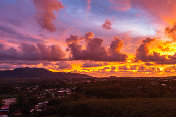 .The sky is painted with hues of deep orange, red, and pink, gradually blending into shades of purple and blue. The clouds reflect these vibrant colors, creating a breathtaking and serene landscape.