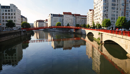 Obraz premium Reflets sur la rivière dans la ville au pont rouge