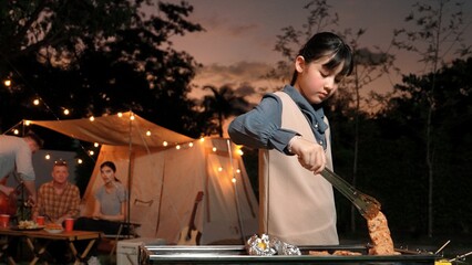 Family gather celebrate holiday, Adorable child grill food for family member. Outdoor camping activity to relax with tasty meal and spend time with young generation cross generation gap. Divergence.