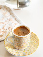 Traditional Turkish coffee cup on the coffee table in a warm environment