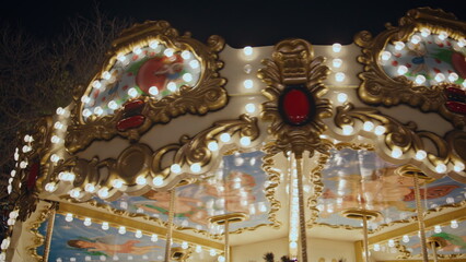 Beautiful carousel glowing lights at night festive scene. Bright roundabout 