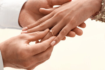 Man putting engagement ring on woman's finger, closeup
