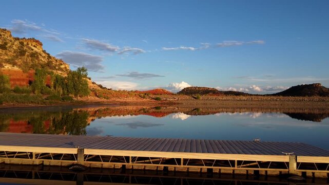 Discover the serene beauty of Escalante State Park in Utah through mesmerizing drone footage at golden hour. Tranquil flight over a lake dock with warm hues of the setting sun