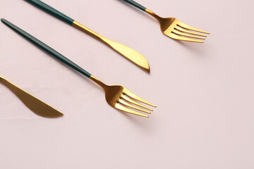 Golden forks and knives with green handles on white background