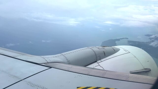 View from plane window flying from Phuket to BKK Bangkok Thailand passing through fluffy white clouds