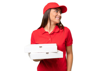 Pizza delivery caucasian woman with work uniform picking up pizza boxes isolated on green chroma background looking side