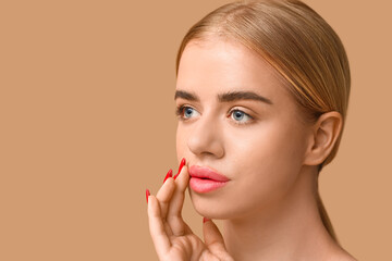 Young woman with beautiful lips on brown background