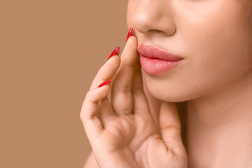 Young woman with beautiful lips on brown background, closeup