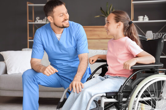 Little girl in wheelchair with nurse talking at home