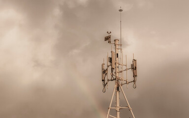 Red white 5G tower radiation with rainbow in Mexico.