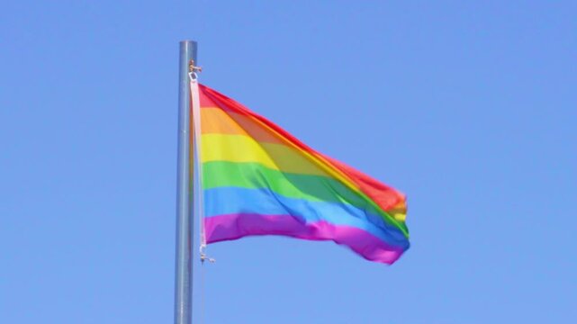 LGBTQ pride, gay, LGBTQ+ flag moving with wind clear blue sky vivid colors no people outdoors outside bright Lanzarote Canary Islands Spain free thinking liberal fight windy sunny one liberalism proud