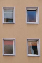 Quirky Window Quartet on Beige Building Facade