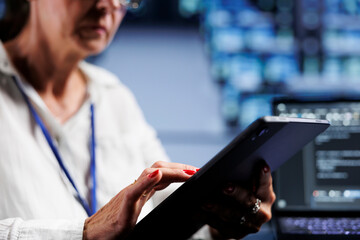 Close up shot of senescent admin writing script code in data center on laptop terminal. Efficient worker doing maintenance work in server room, updating clusters software to prevent malfunctions