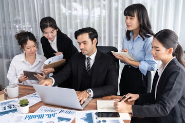 Diverse group of business analyst team analyzing financial data report paper on office table. Chart and graph dashboard by business intelligence analysis for strategic marketing planning Meticulous