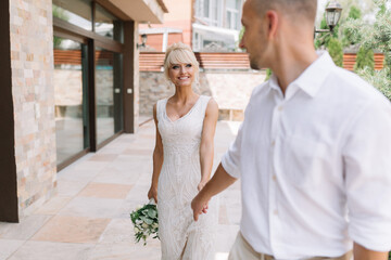 Naklejka premium Happy Newlywed Couple Walking Outdoors in Elegant Wedding Attire