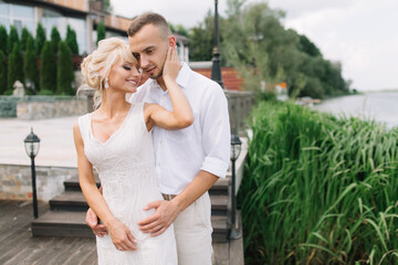 Romantic Couple Embracing Outdoors Near a Lake on a Summer Day