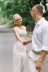 Happy Bride and Groom Strolling Outdoors on Wedding Day in Beautiful Forest Setting