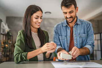 Couple learn and practice how to make a clay figurine, pottery