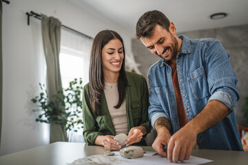 Couple learn and practice how to make a clay figurine, pottery