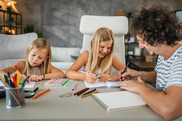 Single father write homework and study with his daughters