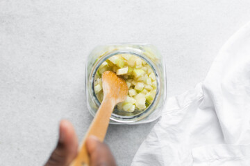 Overhead view of apple cheong in a glass jar on a white background, top view of korean apple cheong in a transparent jar, apple in sugar syrup, process of making apple cheong