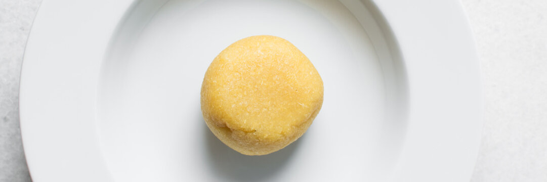 overhead view of Eba on a white plate, Nigerian garri, top view of yellow garri on a white plate