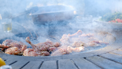 The appetizing appearance of meat grilling on a barbecue in a picnic setting on a summer day