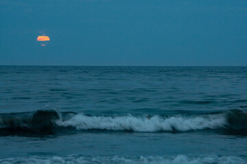 Full moon rises over the Atlantic ocean