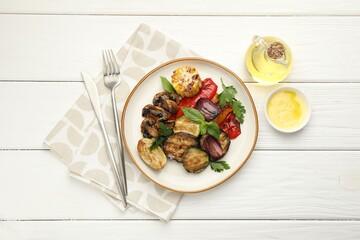 Delicious grilled vegetables with spices served on white wooden table, flat lay