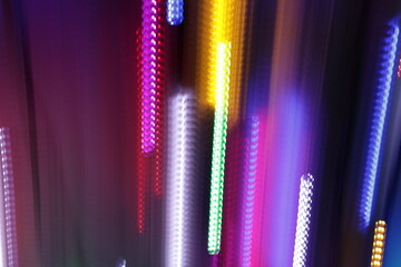 Una toma de cerca de varias luces de colores en movimiento en la oscuridad. Movimiento de cámara